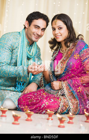 Couple decorating lampes à huile au festival du Diwali Banque D'Images