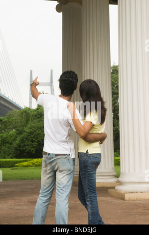 Couple standing at memorial avec pont en arrière-plan, James Famille Prinsep Memorial, Vidyasagar Setu, Kolkata, West Bengal, India Banque D'Images