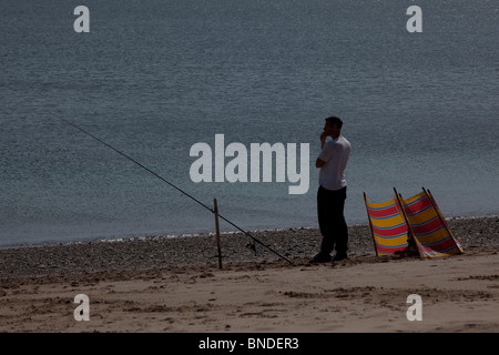 La pêche du bar de la plage, dans le Nord du Pays de Galles, Royaume-Uni. Banque D'Images