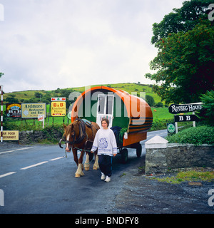 Girl menant cheval roulotte on country road, Comté de Mayo, République d'Irlande Europe Banque D'Images