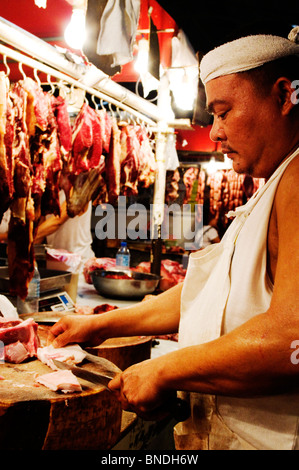 Photos d'un boucher asiatiques dans un marché de la viande au Philippines, Asie. Banque D'Images