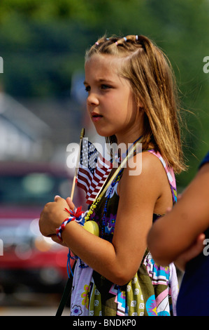 Young Girl Holding drapeau américain tout en regardant la plus ancienne Indépendance Day Parade en Amérique à New Pekin, Indiana Banque D'Images