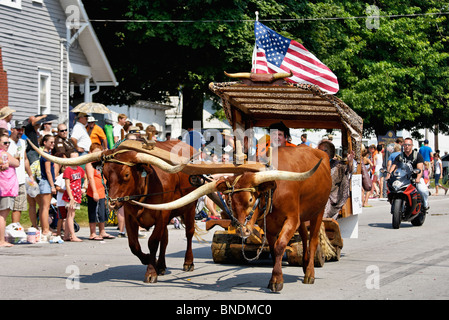 Homme habillé comme Fred Flintstone conduire boeufs dans plus ancienne Indépendance Day Parade en Amérique à New Pekin, Indiana Banque D'Images