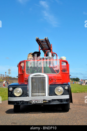 Une miniature 1950 fire engine. Un pilote se prépare à prendre un peu d'enfants pour une balade en elle. Banque D'Images