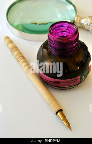 Un stylo de calligraphie, une loupe et un puits d'encre sur une surface blanche. Concept pour la littérature, l'écriture, l'auteur et l'histoire. Banque D'Images