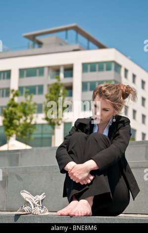 Jeune femme d'affaires inquiets de l'emplacement en plein air dans l'herbe - Chef dans la main Banque D'Images