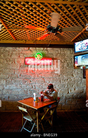 Un homme assis seul dans le restaurant Biergarten Auslander et Hill Country Fredericksburg, au Texas, USA Banque D'Images