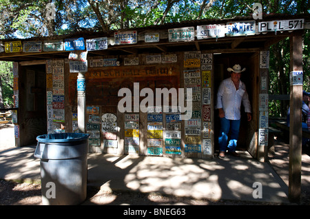 L'homme venant hors de repos avec les plaques d'immatriculation, de Luckenbach, Hill Country, Texas, États-Unis Banque D'Images