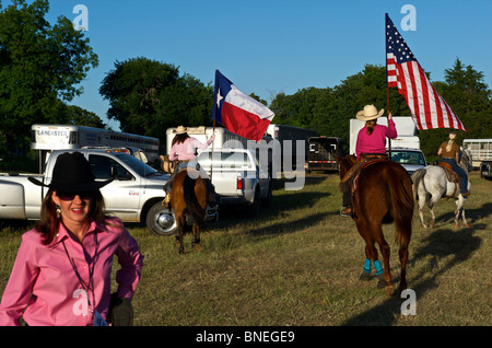 Cowgirls waving flag en bestiaux sur la cérémonie d'ouverture de l'érythroblastopénie événement rodéo au Texas, USA