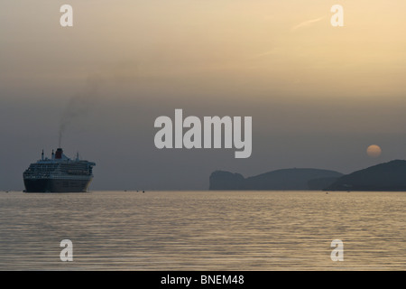 Queen Mary 2 (le plus grand paquebot) administré par Cunard voiles de la baie d'Alghero autour du Capo Caccia en Sardaigne Banque D'Images