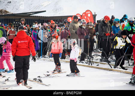 Les enfants apprennent les bases du ski tandis que d'autres font la queue pour le télésiège à Coronet Peak, Queenstown, Nouvelle-Zélande Banque D'Images
