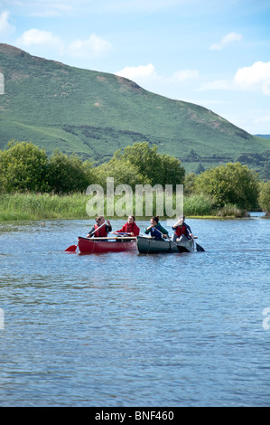 Les jeunes filles bénéficiant d caonoeing sur Derwent Water dans l'été, le Lake District, Cumbria, Royaume-Uni Banque D'Images