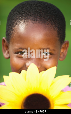 Portrait of Girl (8-9) holding tournesol sur la bouche, Johannesburg, la Province de Gauteng, Afrique du Sud Banque D'Images