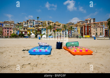 2 Lilos gonflables colorés sur la plage de Villajoyosa, avec des bâtiments de style mauresque dans l'arrière-plan Banque D'Images