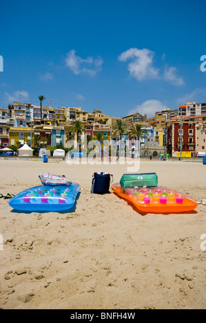 2 Lilos gonflables colorés sur la plage de Villajoyosa, avec des bâtiments de style mauresque dans l'arrière-plan Banque D'Images