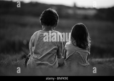 Frère et soeur de mêmes parents bénéficiant d'une soirée tranquille à l'extérieur dans une ferme Banque D'Images