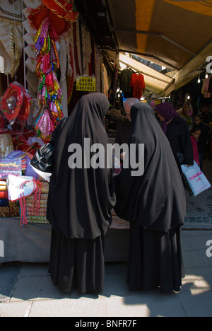 Les femmes voilées intégralement au Grand Bazar shopping extérieur marché de Sultanahmet Istanbul Turquie Europe Banque D'Images