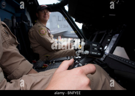 Pilote de l'US Navy se saisit de pas cyclique dans le cockpit d'un hélicoptère Sikorsky MH-60R au Farnborough Airshow. Banque D'Images