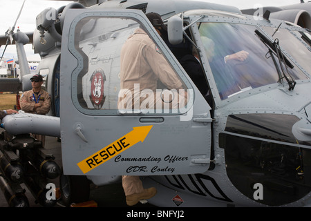 Pilote de la Marine nous montre réduite autour de l'habitacle de leur hélicoptère Sikorsky MH-60R au Farnborough Airshow. Banque D'Images