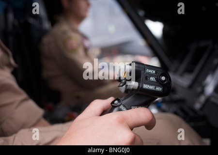 Pilote de l'US Navy se saisit de pas cyclique dans le cockpit d'un hélicoptère Sikorsky MH-60R au Farnborough Airshow. Banque D'Images