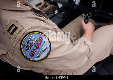 Pilote de l'US Navy se saisit de pas cyclique dans le cockpit d'un hélicoptère Sikorsky MH-60R au Farnborough Airshow. Banque D'Images