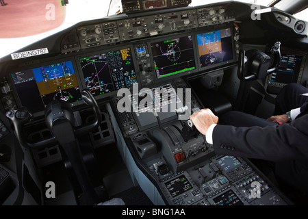 Dans la région de glass cockpit d'écrans LCD, pilote de Boeing avec les mains sur les manettes de 787 Banque D'Images