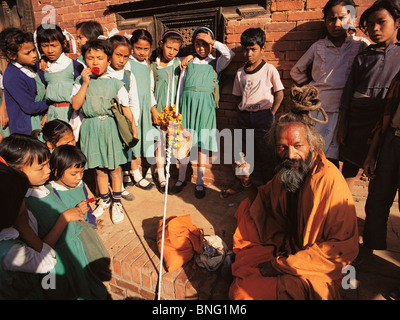 Les écoliers de Patan, Népal, se rassembler autour d'un saint homme hindou ou saddhu Banque D'Images