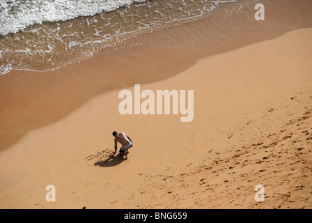 Jeune homme fait "je t'aime' sur la plage Banque D'Images