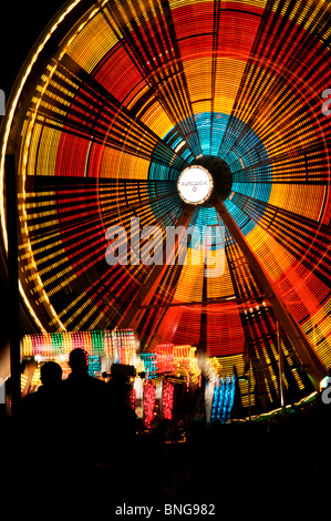 Une pièce lumineuse Ferris roue tourne la nuit durant la célébration de la capitale Lakefair à Olympia, Washington. Banque D'Images