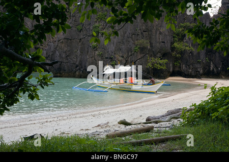 Notre bateau à une plage isolée sur MATINLOC ISLAND près de El Nido dans l'ARCHIPEL DE BACUIT - l'île de Palawan, Philippines Banque D'Images