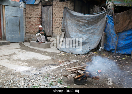 Un vieil homme est assis en face de sa maison, à Srinagar, Jammu-et-Cachemire, en Inde. Banque D'Images