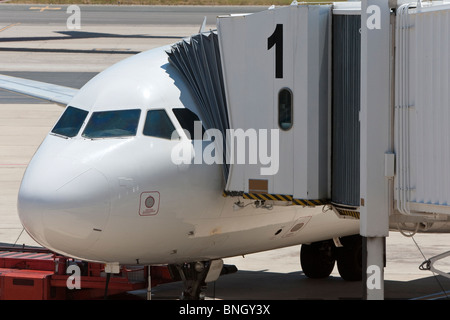 Un avion de ligne ou avion commercial moderne sur la piste à un aéroport avec la passerelle passager en position Banque D'Images