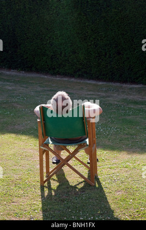 Vieil homme endormi dans une chaise au soleil, Kent, UK Banque D'Images