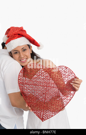 Couple wearing Santa hats et romancing Banque D'Images