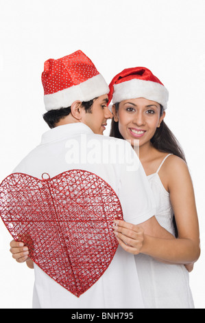 Couple wearing Santa hats et romancing Banque D'Images