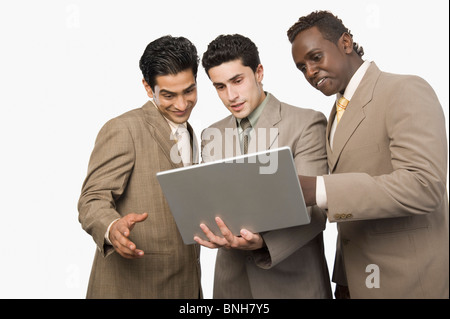 Trois hommes d'article avec un ordinateur portable Banque D'Images