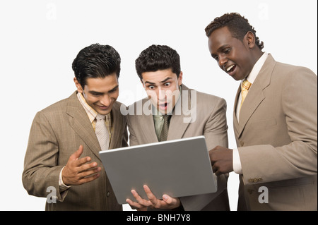 Trois hommes d'article avec un ordinateur portable Banque D'Images