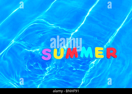 Photo de l'été mot fabriqué à partir de lettres en mousse flottant dans l'eau sur la surface d'une piscine. Banque D'Images
