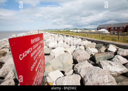 Cailloux mis à essayer de défendre les zones côtières basses du nord du Pays de Galles près de Muro de l'inondation par la mer. Banque D'Images