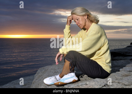 Femme Lever coucher appuie sur un Océan Mer Océan seul Mature Senior vieux problème malheureusement bien triste Nature Solitaire Banque D'Images