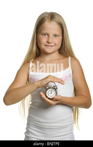 La jeune fille est titulaire d'un réveil dans les mains. Il est isolé sur fond blanc Banque D'Images