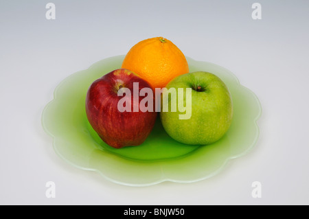 Deux pommes et une orange sur une plaque verte, Andalousie, Espagne, Europe de l'Ouest. Banque D'Images