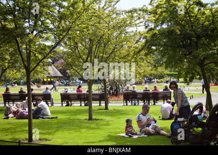 Les gens se détendre sur l'herbe pendant le déjeuner à St Stephen's Green Park, Dublin, Irlande Banque D'Images