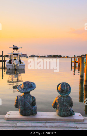 Statues de l'enfant sur un quai au coucher du soleil, Silver Lake Harbour, Ocracoke Island, Cape Hatteras National Seashore, North Carolina, USA Banque D'Images