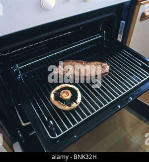 Steak de surlonge cuit et Flat Mushroom sur un gril prises sous un four grill dans un cadre domestique Banque D'Images