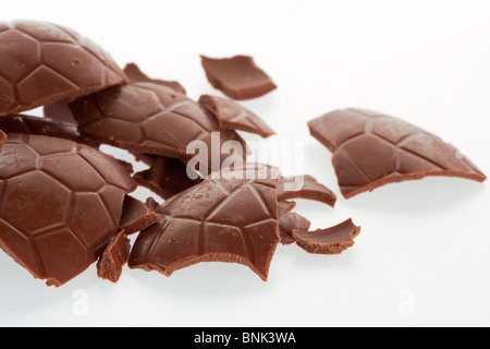 Close-up de morceaux de chocolat au lait œuf de Pâques sur fond blanc Banque D'Images