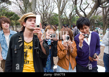 Des jeunes adolescents prenant des photos avec des appareils photos numériques compacts au Parc Yoyogi, Shibuya, Tokyo, Japon Banque D'Images