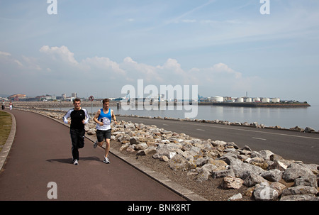 Deux hommes qui la formation sur barrage sur la baie de Cardiff Wales UK Banque D'Images
