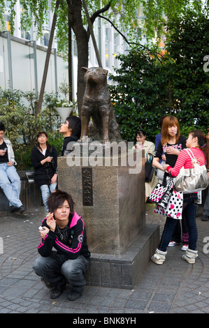 Les jeunes gens en attente pour rencontrer des amis près de la statue du chien Hachiko à l'extérieur de la station Shibuya, Tokyo, Japon Banque D'Images