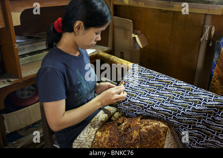 Femme indonésienne de décisions avec batik à la cire chaude à une usine de batik à Yokyakarta, Central Java, Indonésie Banque D'Images